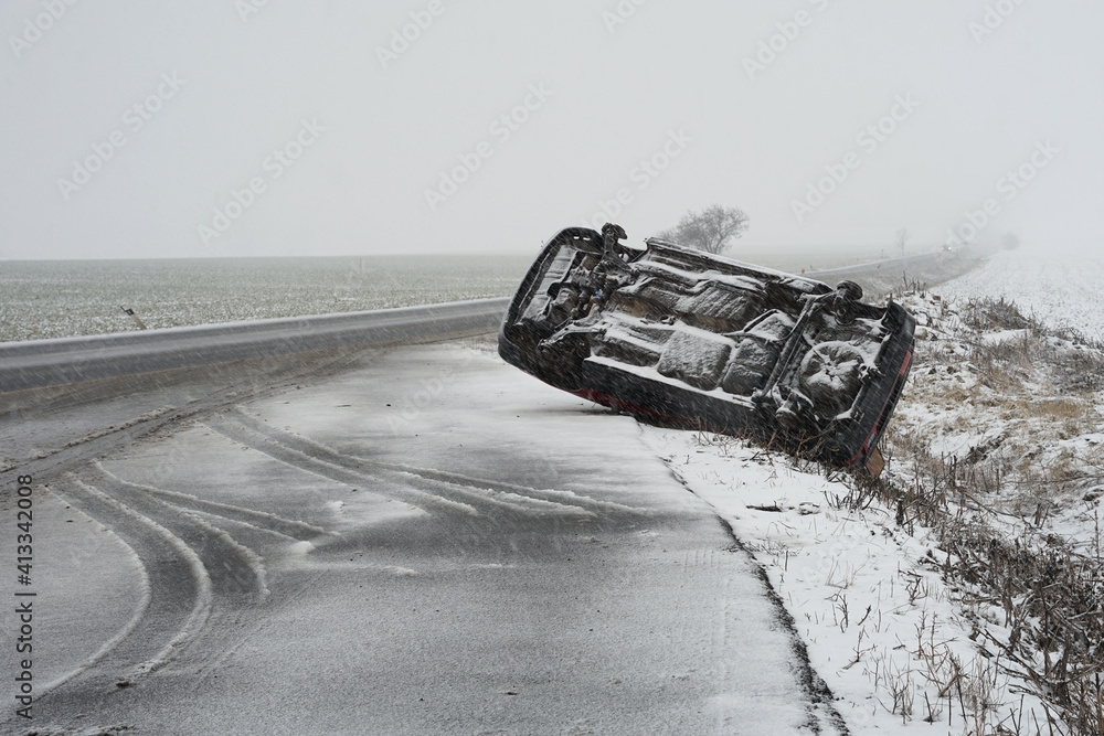 Winter snow condition car accident concept, car lying on its roof after hard collision