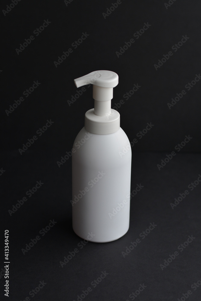 White bottle isolated on black background. Unbrending bottle for mockup. Dishwashing liquid is flowing from bottle. White bottle isolated on black background. Unbrending bottle for mockup. Dishwashing liquid is flowing from bottle.