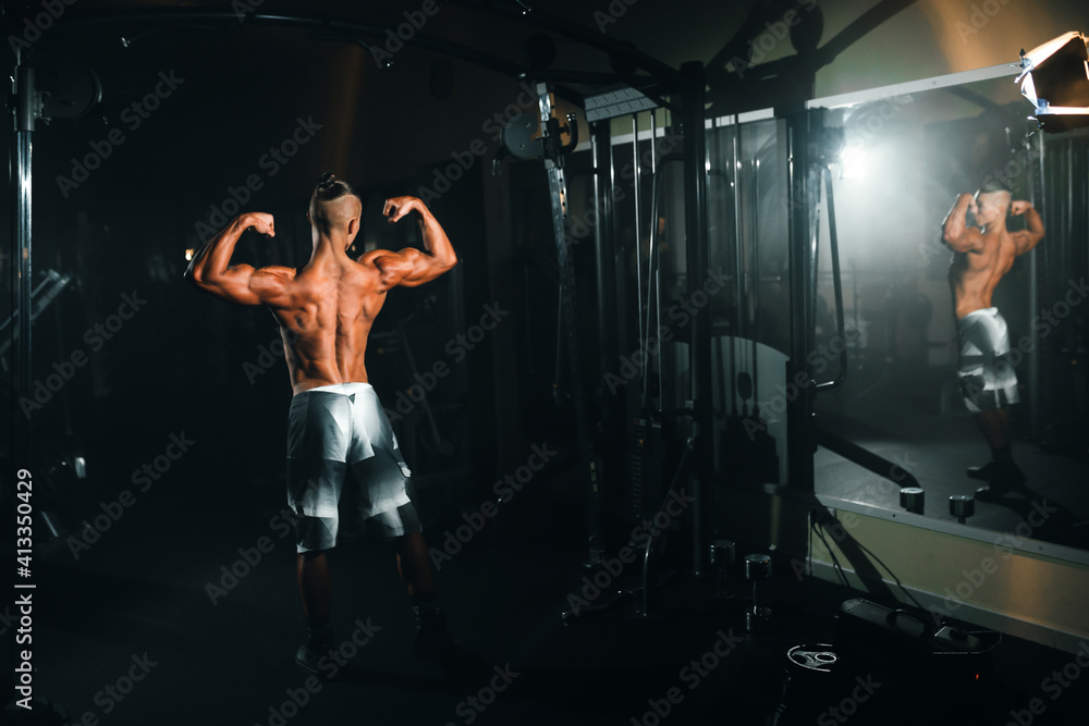 Young sports athlete guy shows muscles in the gym, doing sports, healthy lifestyle. Young sports athlete guy shows muscles in the gym, doing sports, healthy lifestyle.