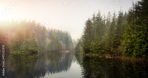 Beautiful Panoramic View of a Scenic Lake with Rain Forest Trees during a foggy winter day. Taken at Rice Lake, Lynn Valley Park, North Vancouver, British Columbia, Canada. Canadian Nature Panorama