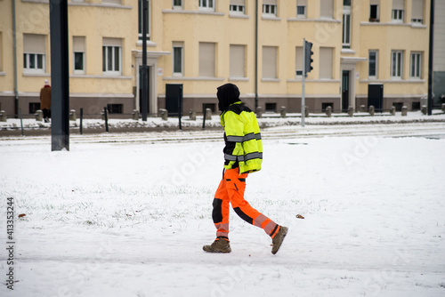 Portrait of worker walking in the street covered by the snow