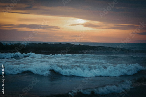 Waves with white foam of the ocean in the light of the evening sun. Bali island