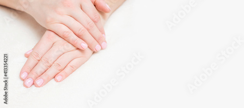 Closeup view of beautiful female hands on towel. Beautiful female hands on towel. Hand care. Woman cares for the nails on hands. Beauty treatment with skin of hand