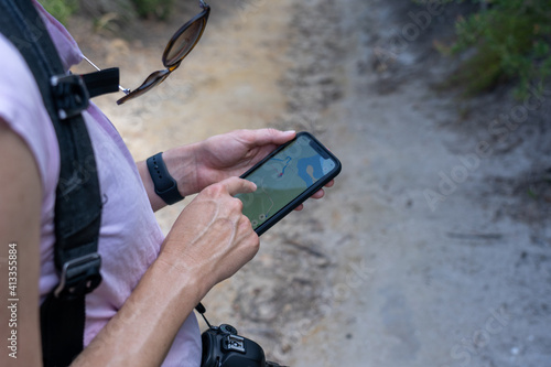 Lady looking up navigation on phone while out on a hike, correct directions