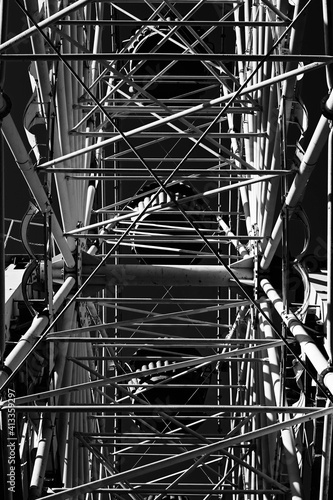 Black and white construction of the Ferris wheel from the inside. Industrial composition of metal architecture beauty. Abandoned damn wheel.