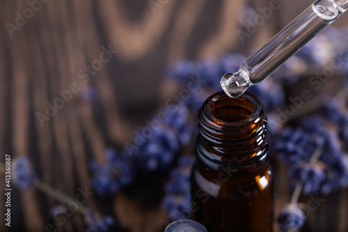 Dripping Lavender essential oil from pipette into glass bottle