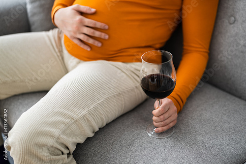 Pregnant Woman Holding Wine Near Belly