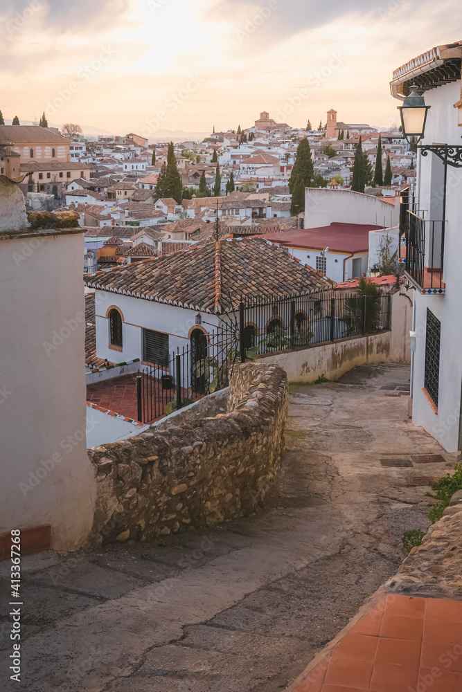 Old town sunset or sunrise view of terracotta rooftops and Granada cityscape in the historic Moorish or Arab Quarter (albaicin) in Granada, Andalusia, Spain.