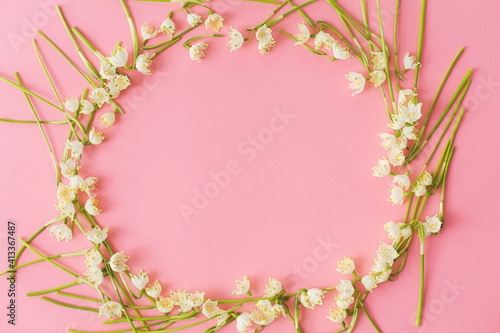 Spring flowers frame flat lay on pink paper. Stylish floral greeting card, copy space. Women's day