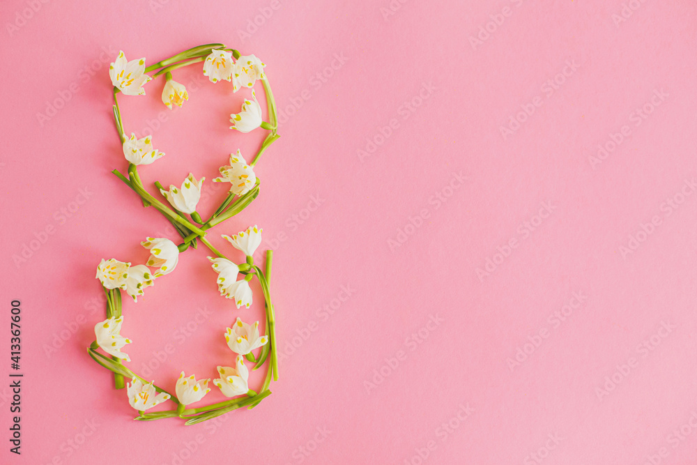 International women's day. Floral 8 march made of spring flowers on pink paper flat lay. International women's day. Floral 8 march made of spring flowers on pink paper flat lay.