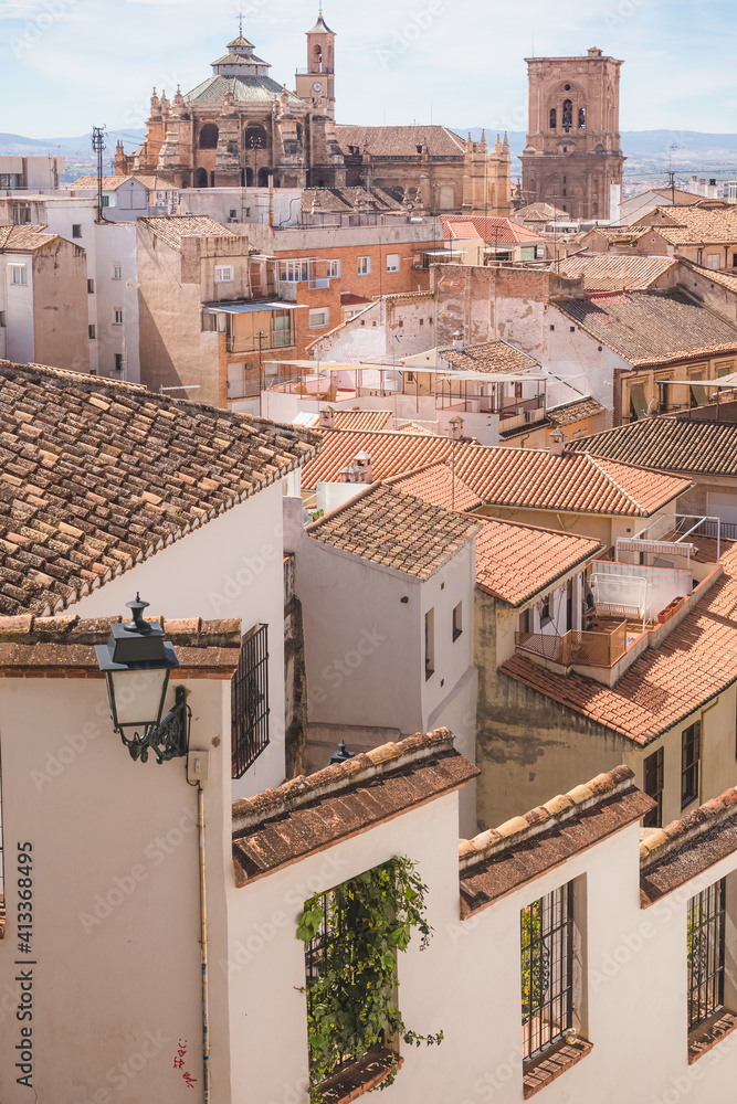 Old town view of terracotta rooftops and Granada Cathedral in the historic Moorish or Arab Quarter (albaicin) in Granada, Andalusia, Spain.