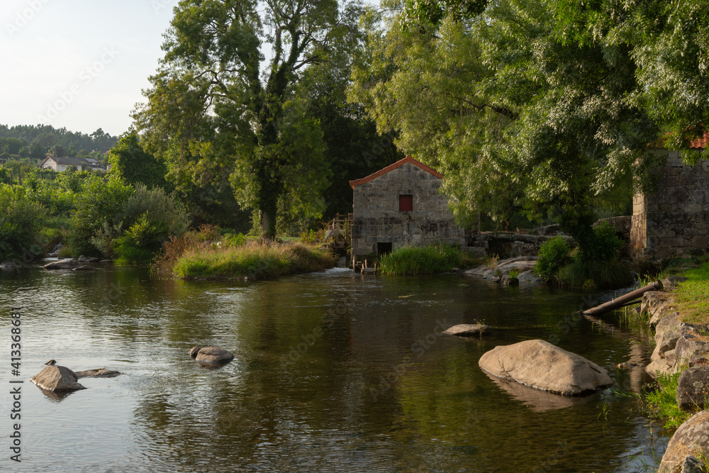 River beach in Vila Verde with a waterfall and water mill in Portugal River beach in Vila Verde with a waterfall and water mill in Portugal