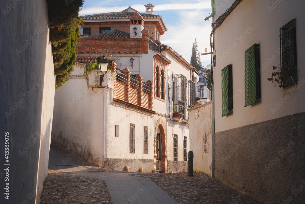 Traditional Moorish architecture on a quiet and quaint narrow cobblestone street in old town (Albaicin or Arab Quarter) Granada, Spain, Andalusia.