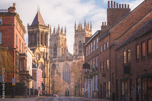 Morning golden light on the historic old town of York along Museum St. looking towards York Minster Cathedral in Yorkshire, England, UK. photo