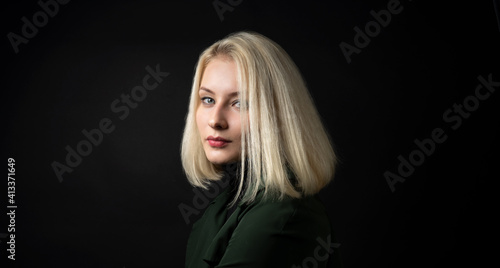close up of pale blonde woman isolated on dark background