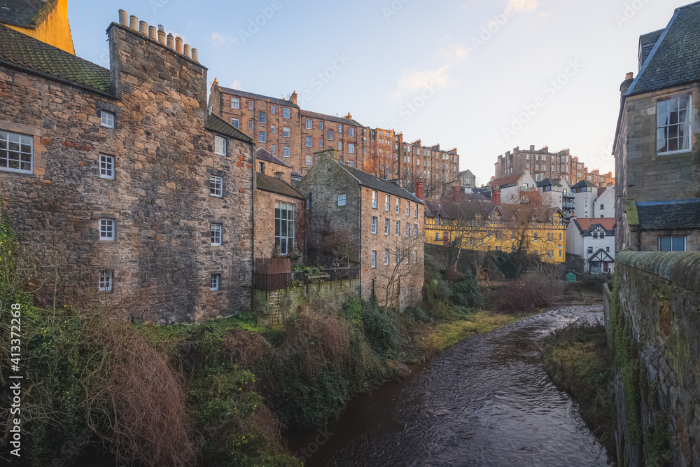View over the Water of Leith and tenement buildings through old town Dean Village in Edinburgh, Scotland on a clear winter afternoon.