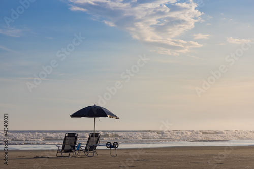 Cadeiras, guarda-sol e carrinho ho isolados em praia ensolarada. Litoral Norte de São Paulo, Guaratuba, Bertioga. 