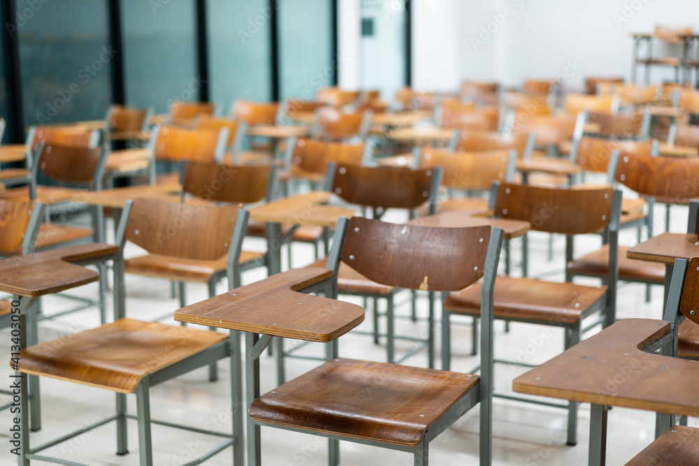 Wooden chairs are well arranged in the classroom. Empty classroom with vintage tone wooden chairs. Back to school concept..