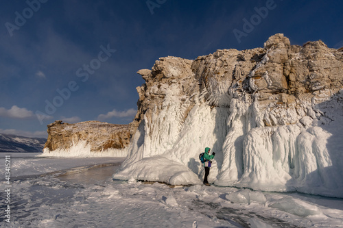 A tourist takes pictures of the icy cliffs of Oltrek Island