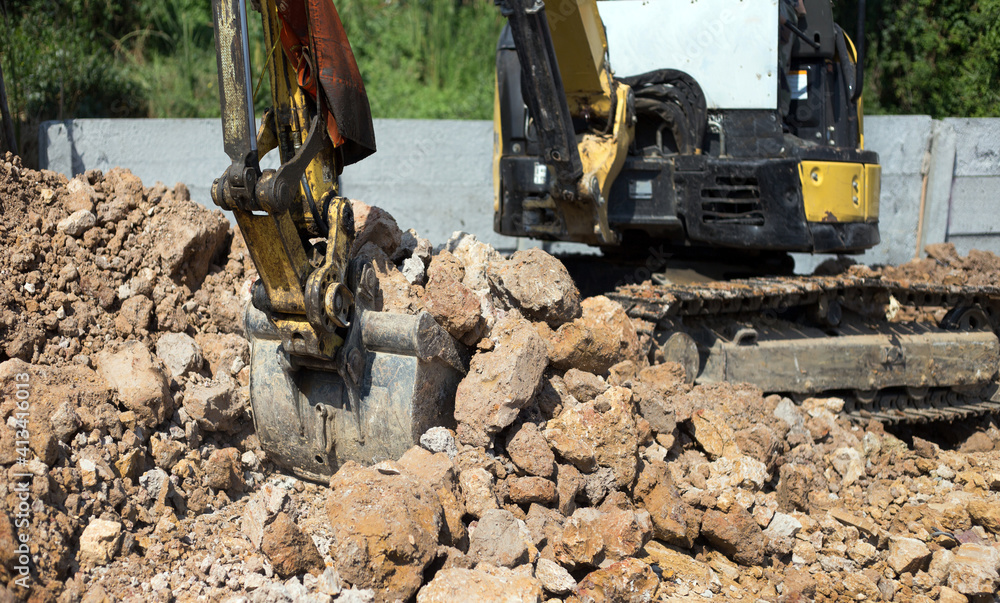 Fototapeta premium Excavator bulldozer in sandpit digging soil o
