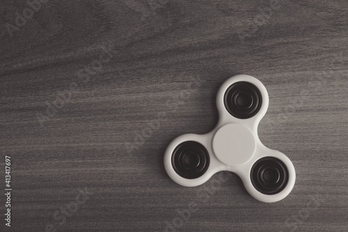 Colourful fidget finger spinner stress, anxiety relief toy on wooden background. Selective focus. photo