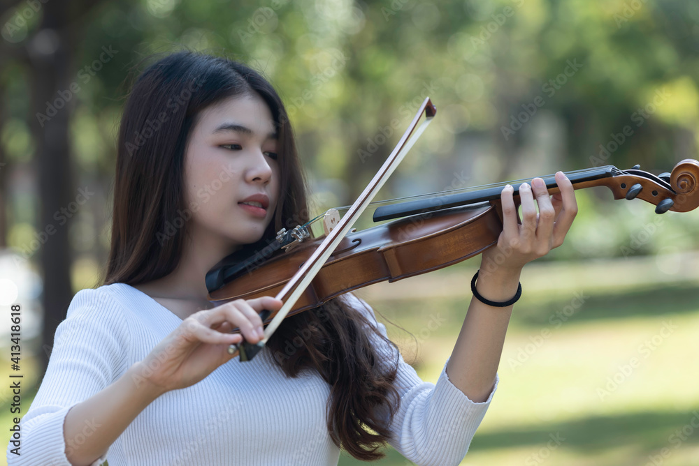 Beautiful asian woman hold violin on nature view background, in emotion feeling happy. Beautiful asian woman hold violin on nature view background, in emotion feeling happy.