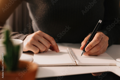 businessman hand working with new modern computer and writing on the notepad strategy diagram