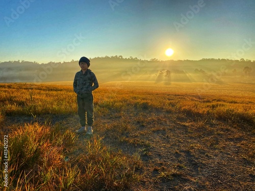 Asian boy at the field while golden sky in the morning 