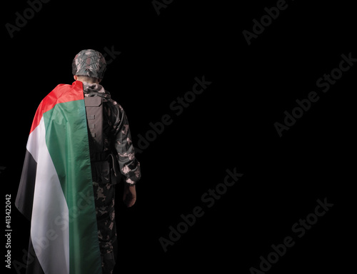 Solider and UAE flag. Concept - UAE national holidays, National Day, Commemoration Day.