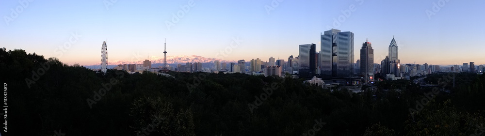 Naklejka premium Wide angle shot of Ürümqi skyline at sunset from Hongshan park, Xinjiang, China