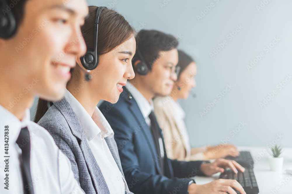 Asian call center team, customer service, telesales in formal suit wearing headset or headphone talking with customer in modern office - obrazy, fototapety, plakaty 