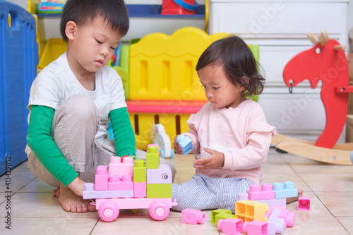 Asian cute big brother and little sister having fun playing with toy blocks in play room at home, Educational toys for young kid, Bonding of sibling, learn through play, child development concept