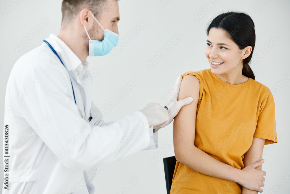 doctor tapes an injection on the shoulder of a happy patient with adhesive tape covid doctor tapes an injection on the shoulder of a happy patient with adhesive tape covid