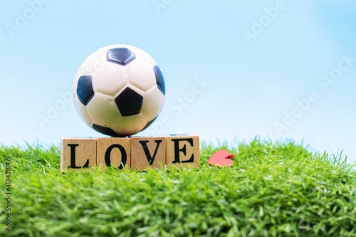 Soccer ball with word LOVE on blue sky background