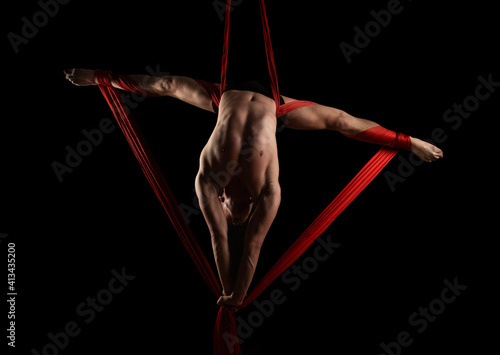 aesthetics of the body, gymnast with red cloth, gymnast on a black background