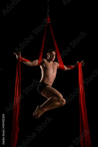 aesthetics of the body, gymnast with red cloth, gymnast on a black background