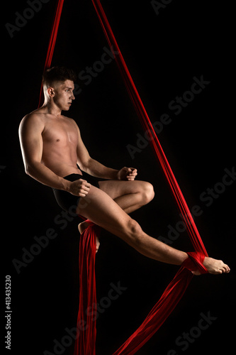aesthetics of the body, gymnast with red cloth, gymnast on a black background