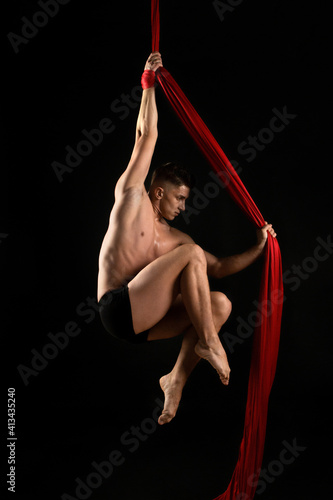 aesthetics of the body, gymnast with red cloth, gymnast on a black background