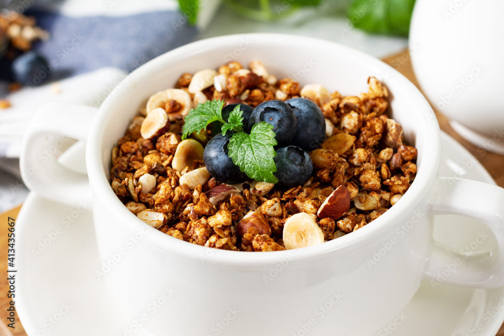 Homemade granola made from buckwheat. Organic buckwheat granola, green buckwheat sprouts, hazelnuts, pumpkin seeds, flax seeds and nutmeg. Granola in a white plate on the light gray kitchen table Homemade granola made from buckwheat. Organic buckwheat granola, green buckwheat sprouts, hazelnuts, pumpkin seeds, flax seeds and nutmeg. Granola in a white plate on the light gray kitchen table