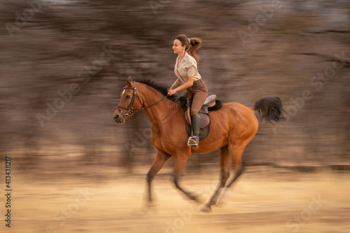 Obraz na plátne Slow pan of brunette riding past trees