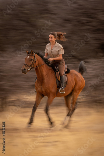 Slow pan of brunette riding past woods