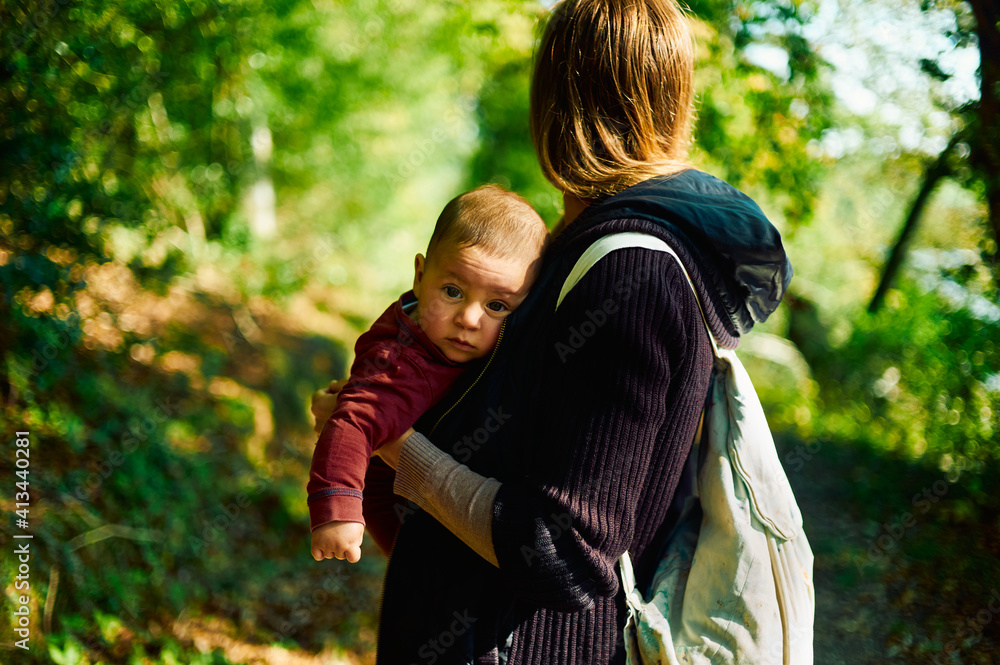 Young mother with baby in the woods on an autumn day Young mother with baby in the woods on an autumn day