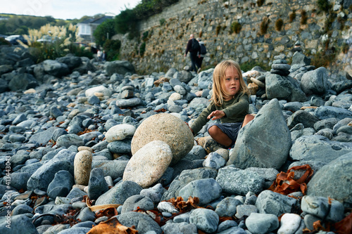 Preschooler playing with rocks in the autumn on beach