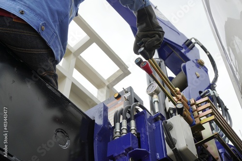 Workers are controlling boom truck or truck loader to upload equipment and machinery into the construction site in the chemical industry. photo