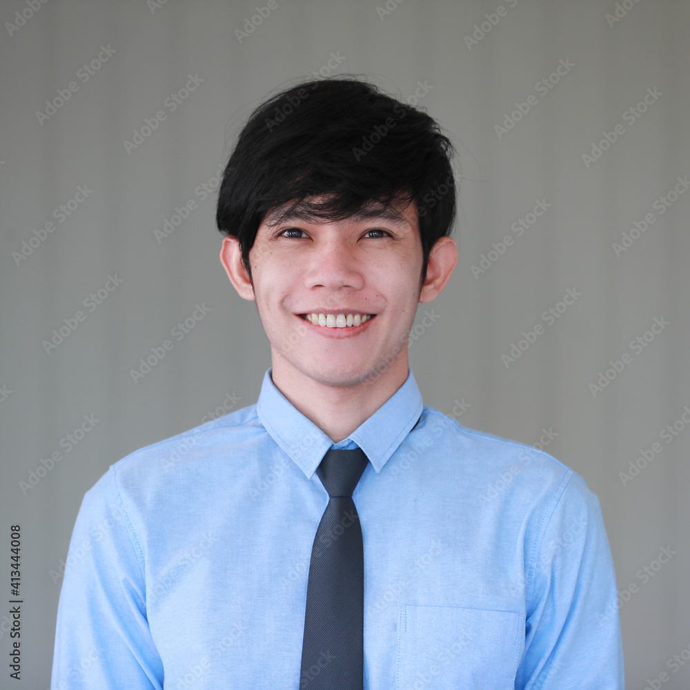 Junior young good looking Asain businessman in shirt and necktie pose with smile face and friendly positive gesture Junior young good looking Asain businessman in shirt and necktie pose with smile face and friendly positive gesture