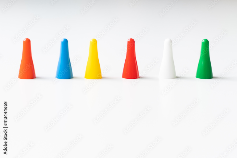 Multi-colored playing chips and dice cubes are grouped together on a white background: the concept of Board games, entertainment, background, games at home for the whole family Multi-colored playing chips and dice cubes are grouped together on a white background: the concept of Board games, entertainment, background, games at home for the whole family
