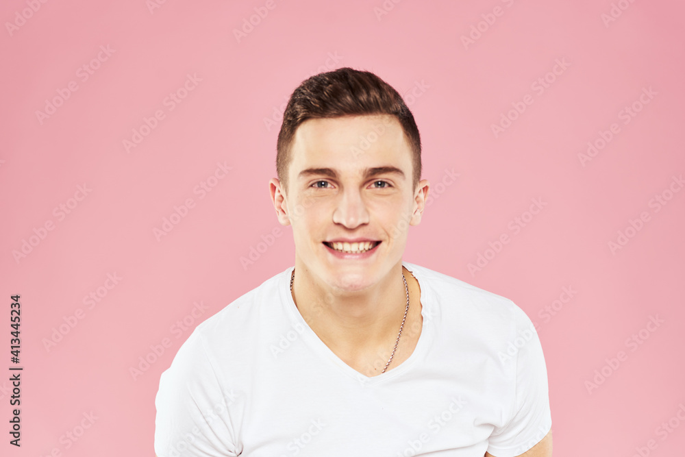 Cheerful handsome man in white t-shirt emotions pink isolated background Cheerful handsome man in white t-shirt emotions pink isolated background