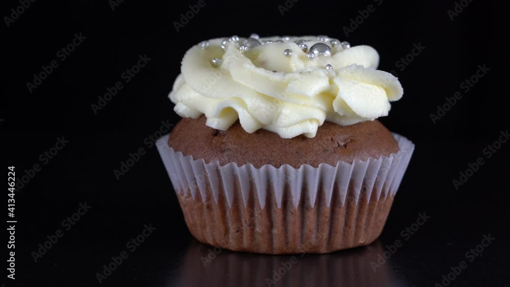 Fragrant, vanilla cupcake with berry filling and honey cream cheese on black background, close up, rotates Fragrant, vanilla cupcake with berry filling and honey cream cheese on black background, close up, rotates