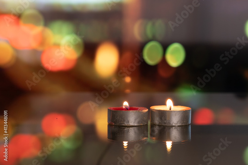 candles on glass table, moving blurred colorful city night in background.