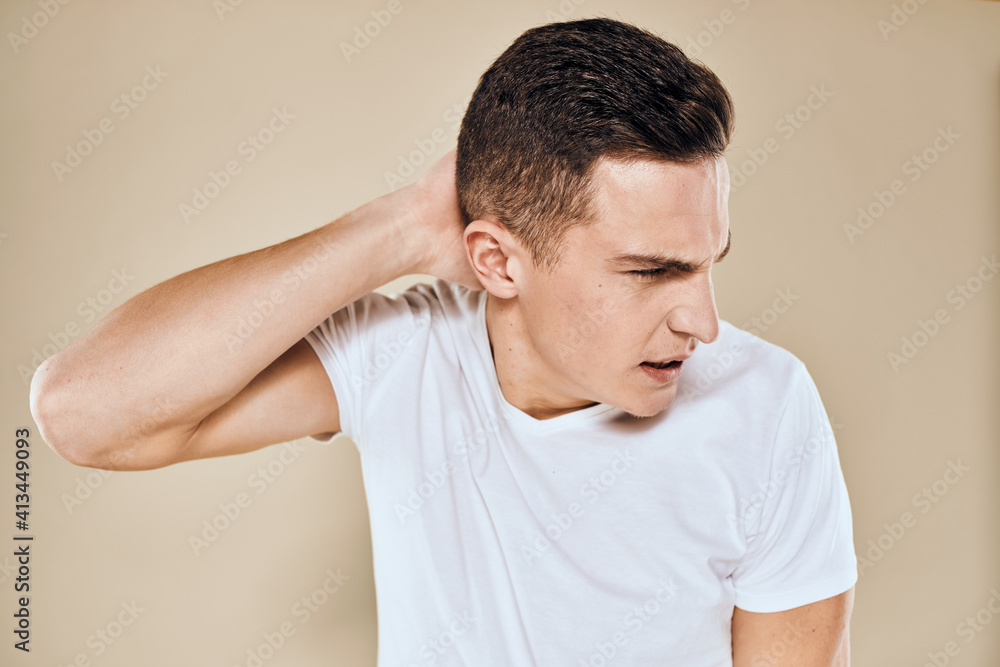Man with displeased facial expression emotions white t-shirt gestures with hands beige background Man with displeased facial expression emotions white t-shirt gestures with hands beige background